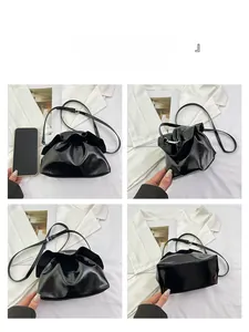 Detail view of black glossy ruched shoulder bag with phone for size comparison