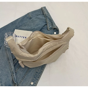 Détail de l'intérieur du sac en nylon beige avec compartiments et fermeture à corde