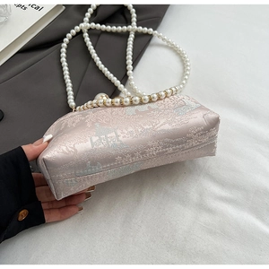 Detail of pink satin evening bag with silver embroidery and elegant pearl handle straps
