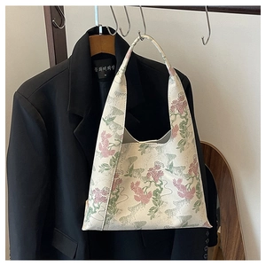 Detail of high-density floral jacquard fabric on a cream white bucket bag with embroidery