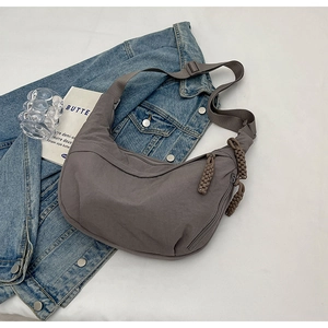 Détail du sac hobo en nylon taupe avec large bandoulière et tirette de zip tissée