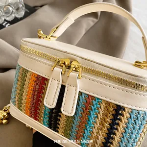 Close-up of colorful woven box bag featuring smooth gold zippers and white faux leather trim