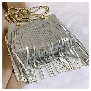 Détail du sac à bandoulière argenté à franges avec chaîne dorée sur fond élégant