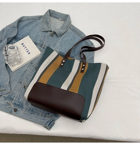 Detail of striped canvas tote bag with teal and yellow patterns and leather bottom