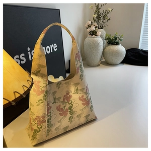 Detail of vintage Chinese floral embroidery on cream jacquard underarm bucket bag