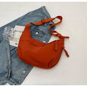 Vue détaillée du sac croissant en nylon orange avec bandoulière réglable et zip tressé