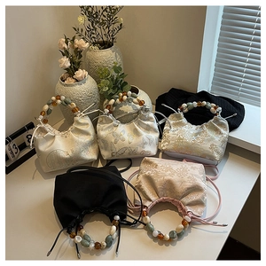 Vue détaillée de sacs à cordon en satin avec d'élégantes poignées en perles colorées