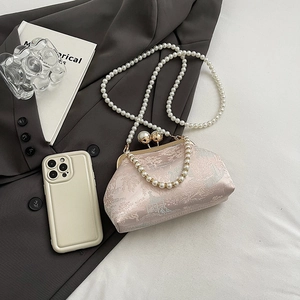 Detail of pink jacquard qipao bag with large pearl clasp and elegant floral patterns