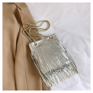 Détail du sac à bandoulière argenté avec pompons métalliques et chaîne dorée