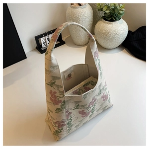 Detailed macro view showing the floral embroidery texture and magnetic clasp of the hobo bag