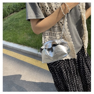 Detail shot of the silver metallic cloud bag with gathered texture and thin shoulder strap