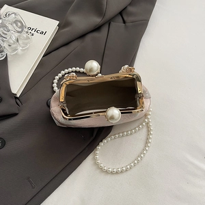 Detail of pink jacquard qipao bag with large pearls and vintage gold clasp closure