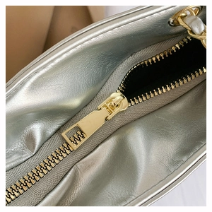 Détail du sac en cuir argenté métallisé avec fermeture éclair dorée haut de gamme et texture