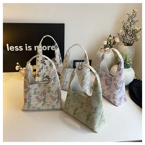 Close-up of vintage floral embroidery on high-capacity canvas hobo bags in soft colors