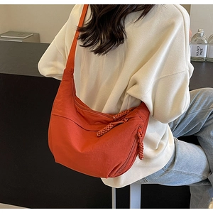 Détail du sac croissant en nylon rouge brique avec fermeture en corde tressée