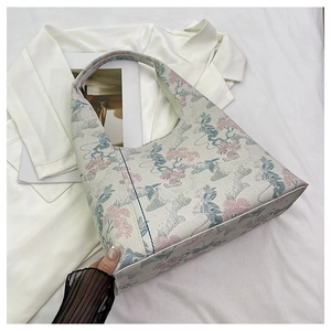 Detail of Chinese style crescent bag featuring elegant floral embroidery and fabric texture