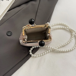 Close-up of pink floral embroidery bag with pearl chain and internal lining detail