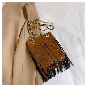 Gros plan du sac bandoulière marron vintage avec franges et chaînes dorées