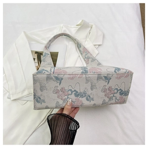 Close-up of vintage floral embroidery and crane pattern on the jacquard fabric bag