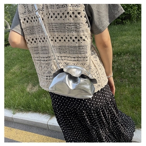 Outdoor look of metallic silver cloud bag with pleated design and matching strap