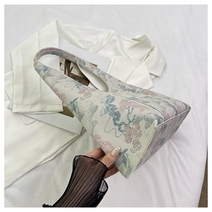 Detailed view of vintage floral embroidery on a jacquard bucket bag with oriental patterns