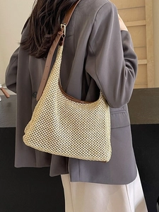Chic straw woven shoulder bag with brown leather trim shown on model for summer beach trips