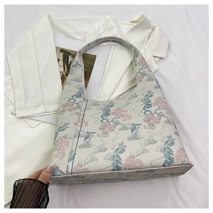 Detailed macro view of the intricate floral pine embroidery on the jacquard fabric bag