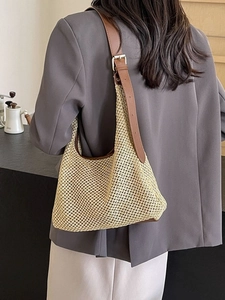 Minimalist summer woven straw hobo bag with leather trim and adjustable strap shown on model