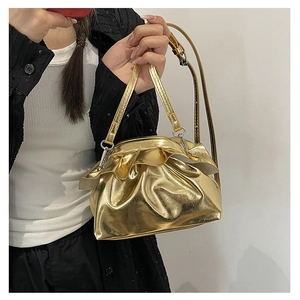 Detailed view of the metallic gold pleated cloud bag with elegant ruched texture