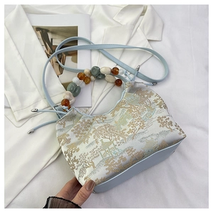 Détail du sac jacquard bleu avec poignée en perles de résine colorées et bandoulière