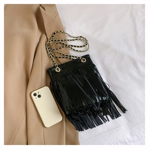 Détail du sac à bandoulière noir à franges avec texture brillante et chaîne dorée