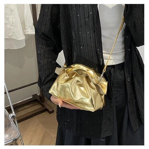 Side view of a metallic gold cloud-shaped crossbody bag with stylish pleated edge