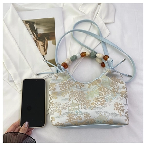 Vue détaillée du sac à broderie chinoise avec poignée en perles et bandoulière bleue