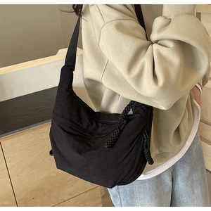 Gros plan du sac hobo en nylon plissé noir montrant la texture et le zip en corde