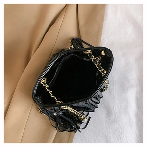 Détail du sac à franges noir montrant la chaîne dorée et la poche zippée interne