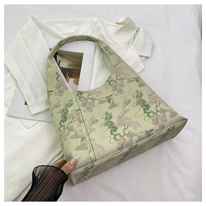 Detail of vintage floral embroidery and jacquard texture on green bucket bag