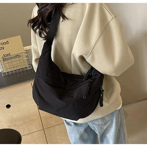 Détail du sac dumpling en nylon noir avec tirettes de fermeture en corde épaisse tressée