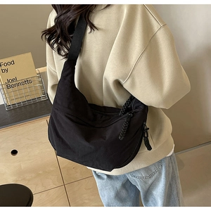 Vue détaillée du sac demi-lune en nylon noir avec tirette de fermeture tressée
