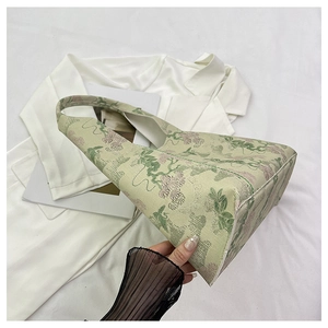 Detailed view of floral embroidery on a light green jacquard water bucket bag