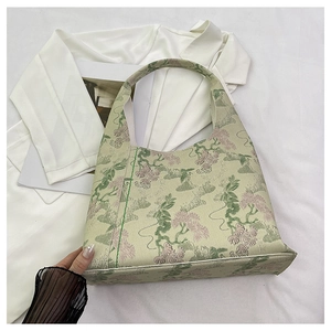 Close-up of light green floral jacquard fabric with pine tree embroidery on bucket bag
