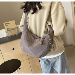 Détail d'un grand sac bandoulière en nylon avec une tirette de fermeture éclair tressée