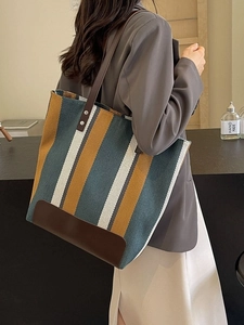 Striped canvas tote bag with brown leather handles and large capacity design