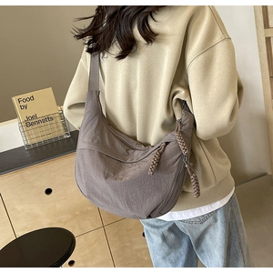 Détail du grand sac demi-lune en nylon taupe avec fermeture en corde tressée et texture