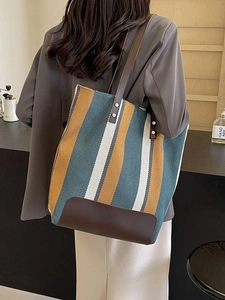 Striped knit tote bag with leather trim and wide straps for stylish commuting