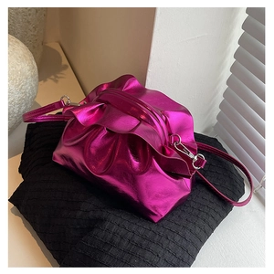 Detailed view of fuchsia pleated cloud bag with metallic finish and silver strap hooks