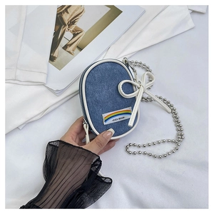Detalle del mini bolso bandolera de mezclilla con lazo de cuero blanco y cadena de metal