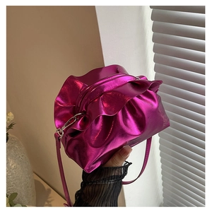 Detail showing metallic rose red pleated cloud bag with drawstring and thin shoulder strap