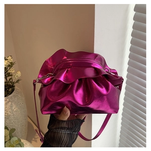 Detail of metallic rose red ruched clutch bag with wavy trim and slim shoulder strap