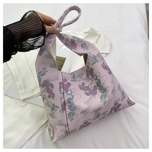 Detailed embroidery of pine and crane patterns on pink canvas bucket handbag