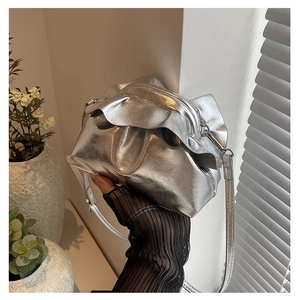 Detail of silver metallic cloud bag with stylish folds and adjustable slim shoulder strap